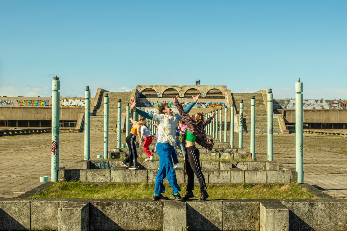 Young people are dancing outside whilst on a trip to Estonia.